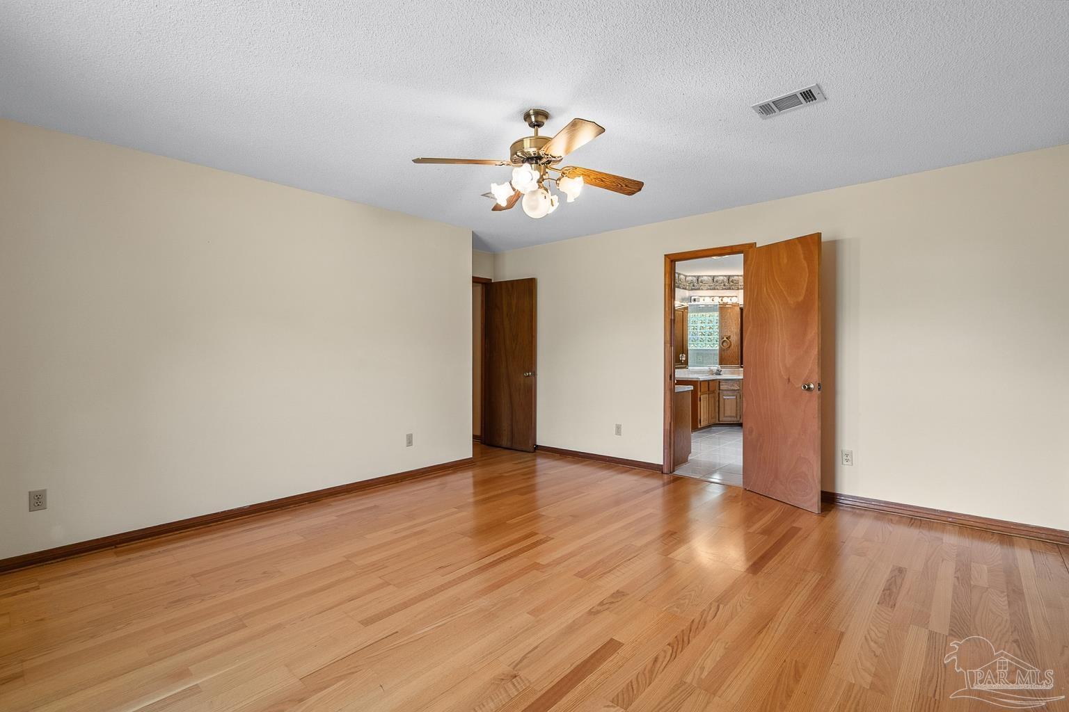 6160 Saddle Club Road Pace, FL 32571 - Photo 30 of 49 an empty room with wooden floor chandelier fan and windows