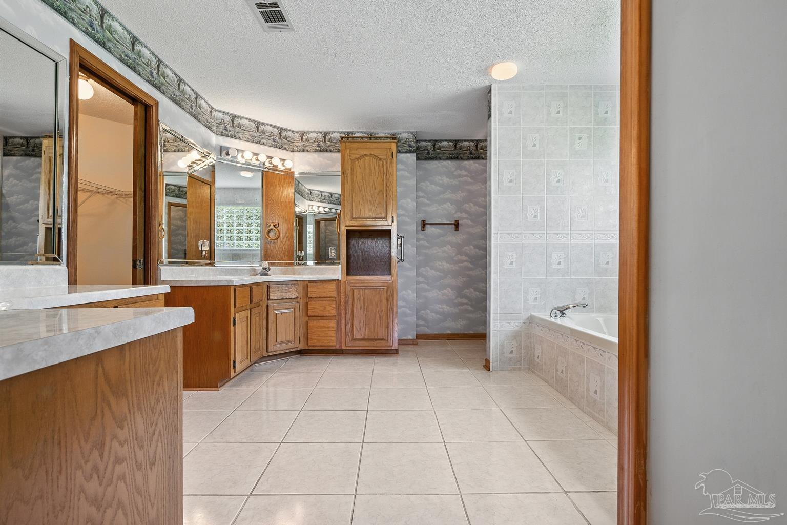 6160 Saddle Club Road Pace, FL 32571 - Photo 31 of 49 a bathroom with a tub a sink a mirror and a shower
