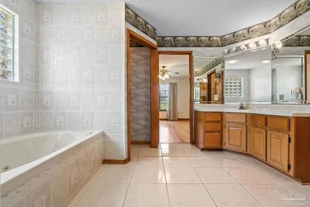 a spacious bathroom with a granite countertop sink mirror and bathtub