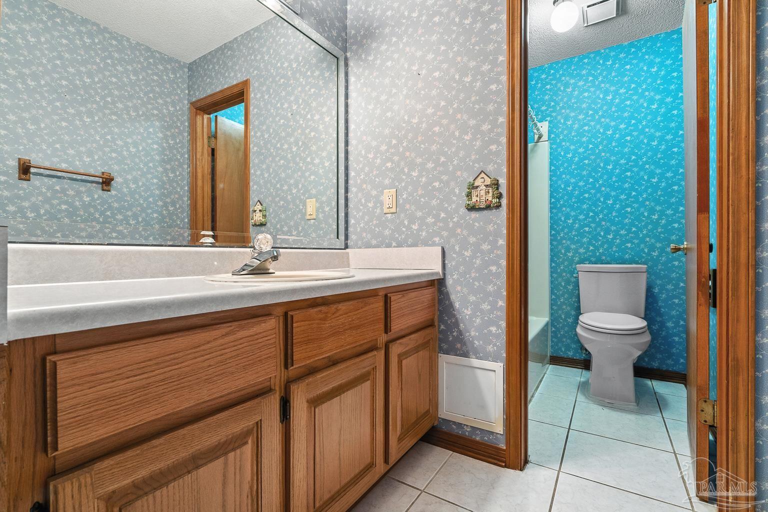 6160 Saddle Club Road Pace, FL 32571 - Photo 39 of 49 a bathroom with a sink a toilet and mirror