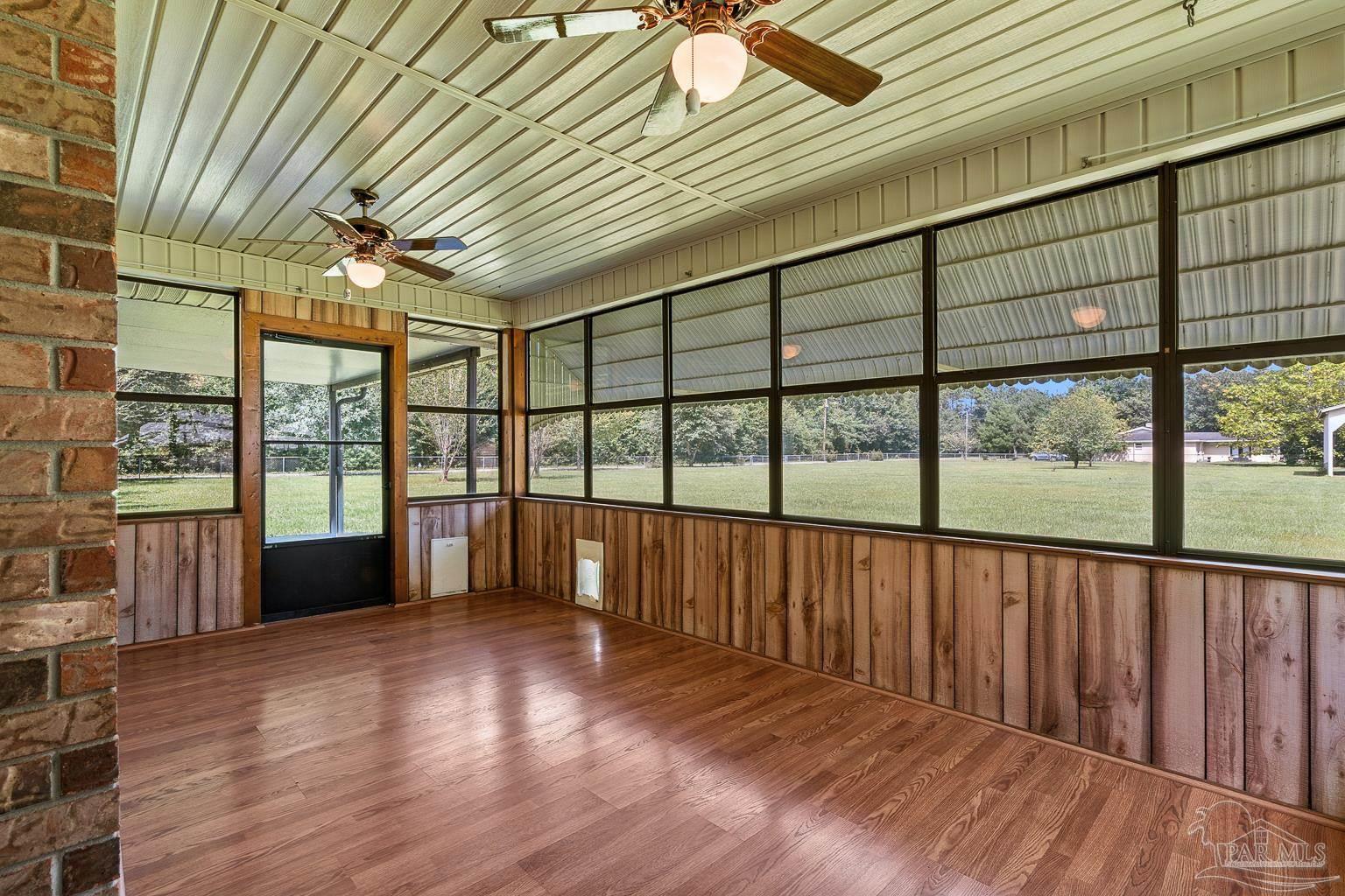 6160 Saddle Club Road Pace, FL 32571 - Photo 45 of 49 a view of an empty room with wooden floor and a window