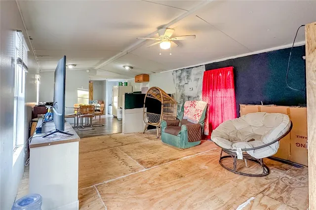 a living room with furniture a rug and kitchen view