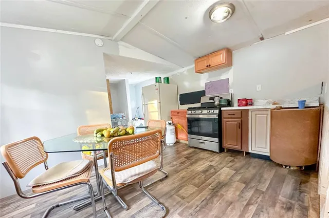 a living room with furniture a flat screen tv and kitchen view
