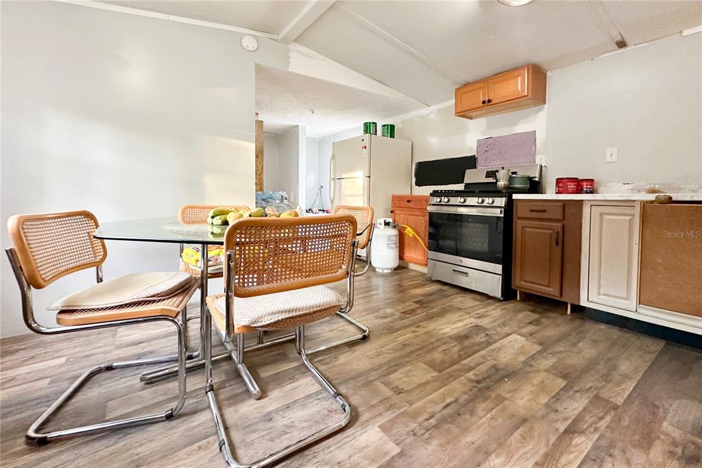 198 Spurlock Road Frostproof, FL 33843 - Photo 17 of 50 a living room with furniture a flat screen tv and kitchen view