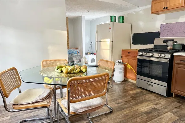 a kitchen with a stove a refrigerator and a stove with wooden floors