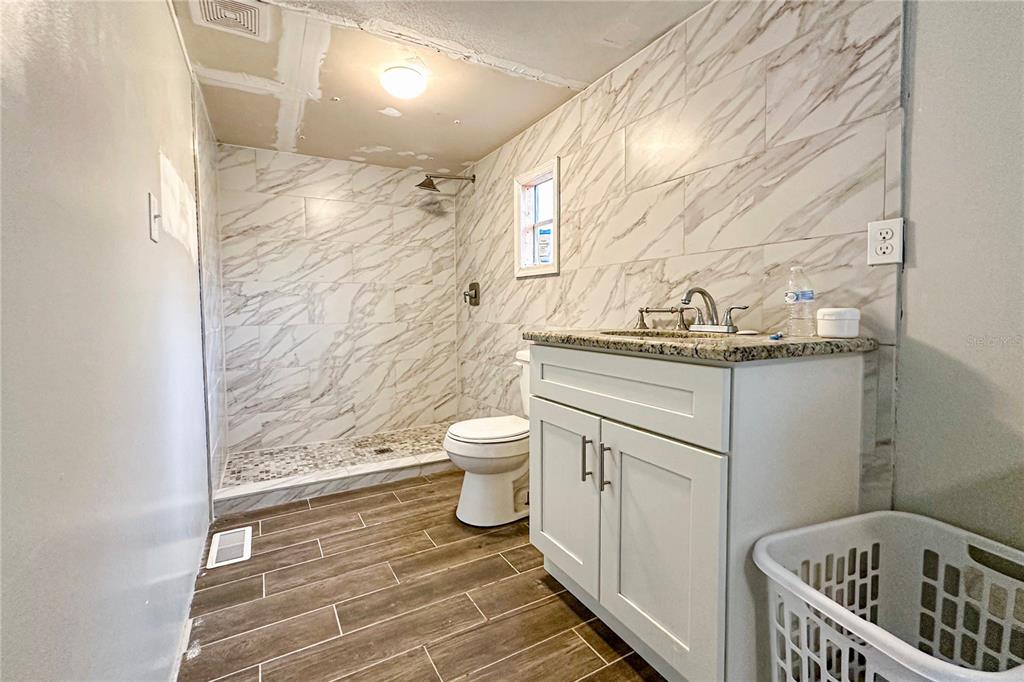 198 Spurlock Road Frostproof, FL 33843 - Photo 26 of 50 a bathroom with a granite countertop toilet a sink and a mirror