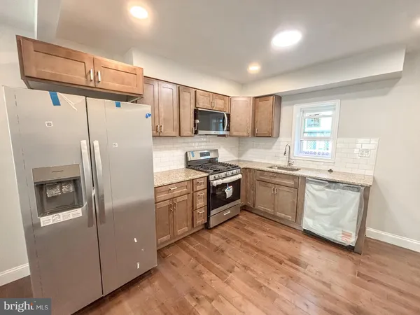 a kitchen with stainless steel appliances a refrigerator sink and microwave