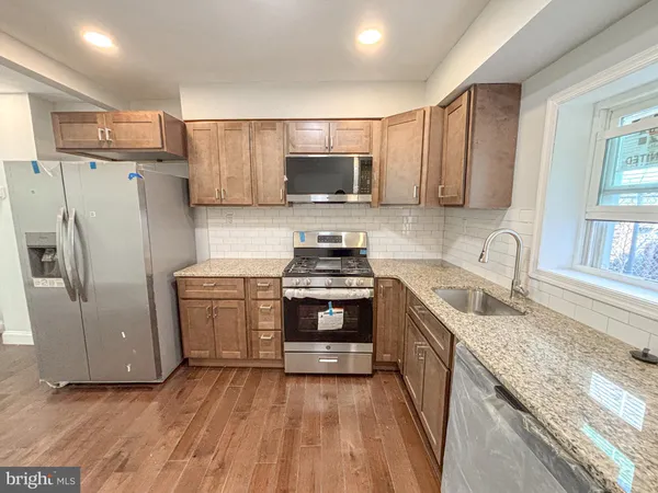 a kitchen with granite countertop a refrigerator stove and microwave