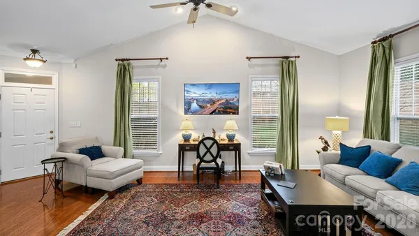a view of a dining room with furniture a chandelier and wooden floor
