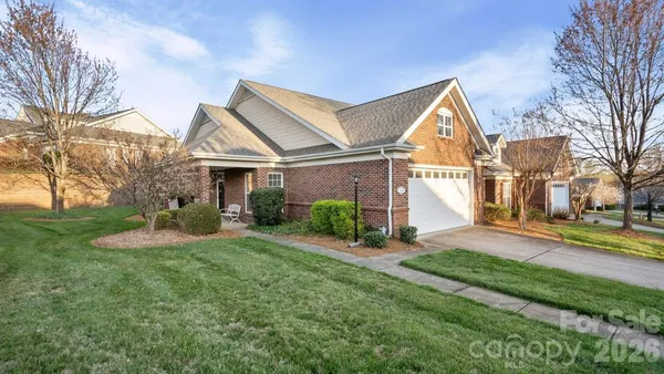 a view of a house with a big yard and large tree