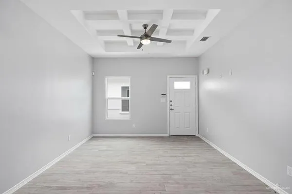 an empty room with a ceiling fan and window