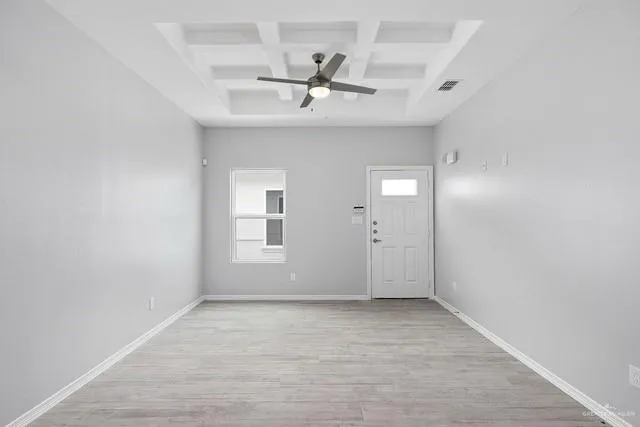 an empty room with a ceiling fan and window