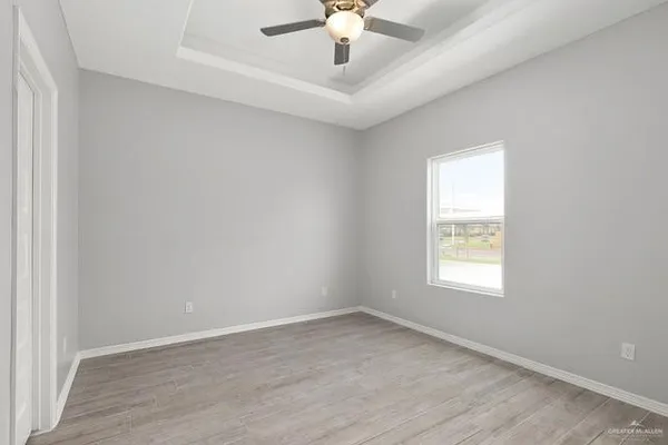 an empty room with a window and a ceiling fan