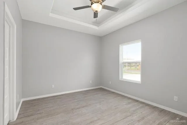 an empty room with a window and a ceiling fan