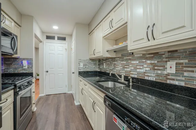 a kitchen with stainless steel appliances granite countertop a sink and a stove
