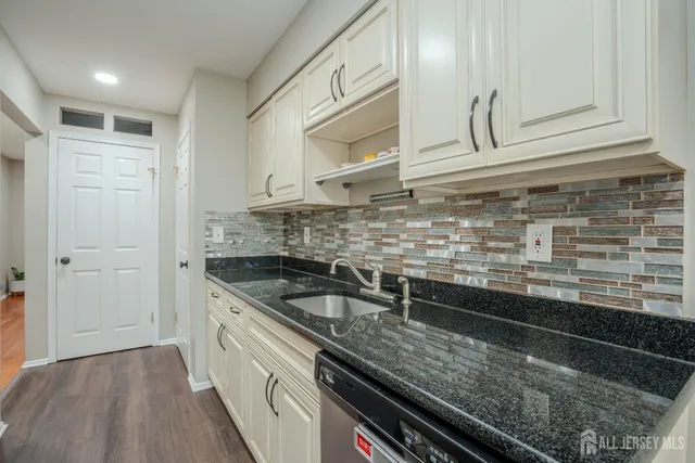 a kitchen with stainless steel appliances granite countertop a sink and wooden cabinets