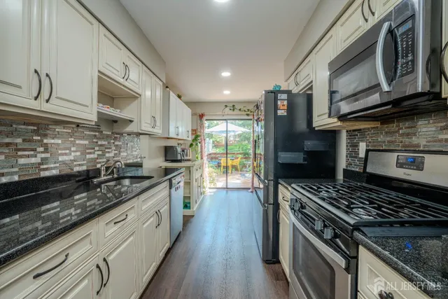 a large kitchen with stainless steel appliances granite countertop a stove and a sink