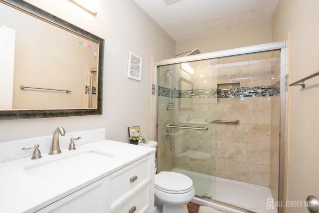a bathroom with a sink vanity mirror and toilet
