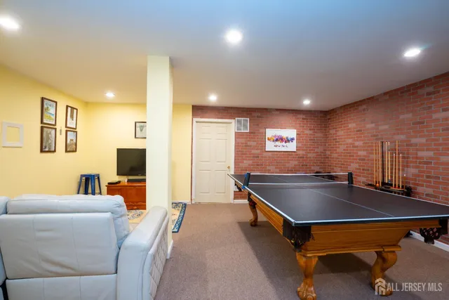 a living room with furniture pool table and a flat screen tv