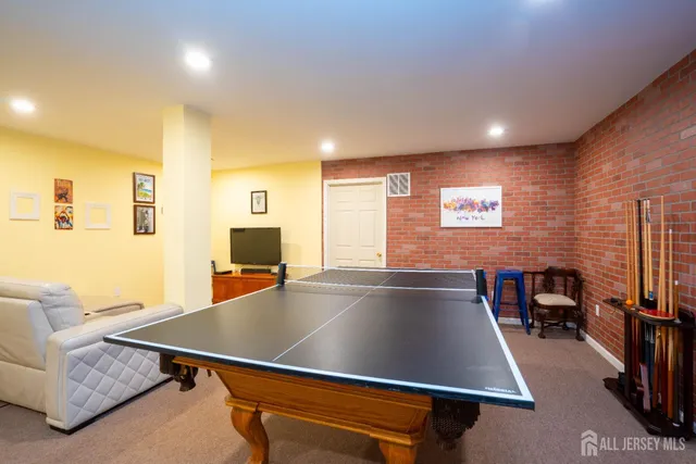 a room with chairs pool table and a large window