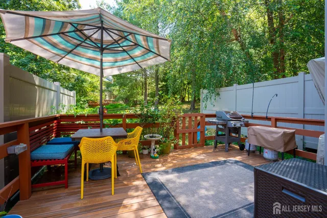 a view of backyard with seating space and wooden fence