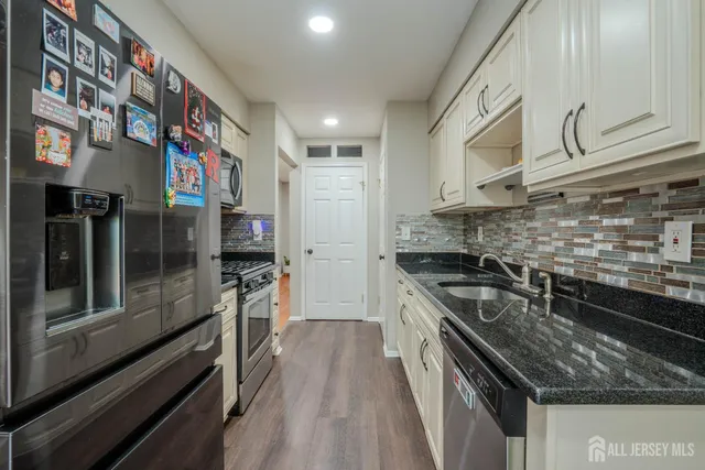 a kitchen with stainless steel appliances granite countertop a stove and a refrigerator