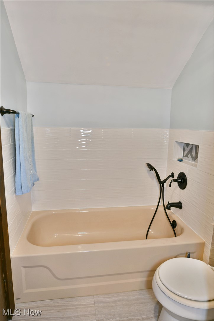 1509 State Road Northwest Warren, OH 44481 - Photo 30 of 49 Bathroom with toilet, lofted ceiling, tile patterned floors, and tile walls