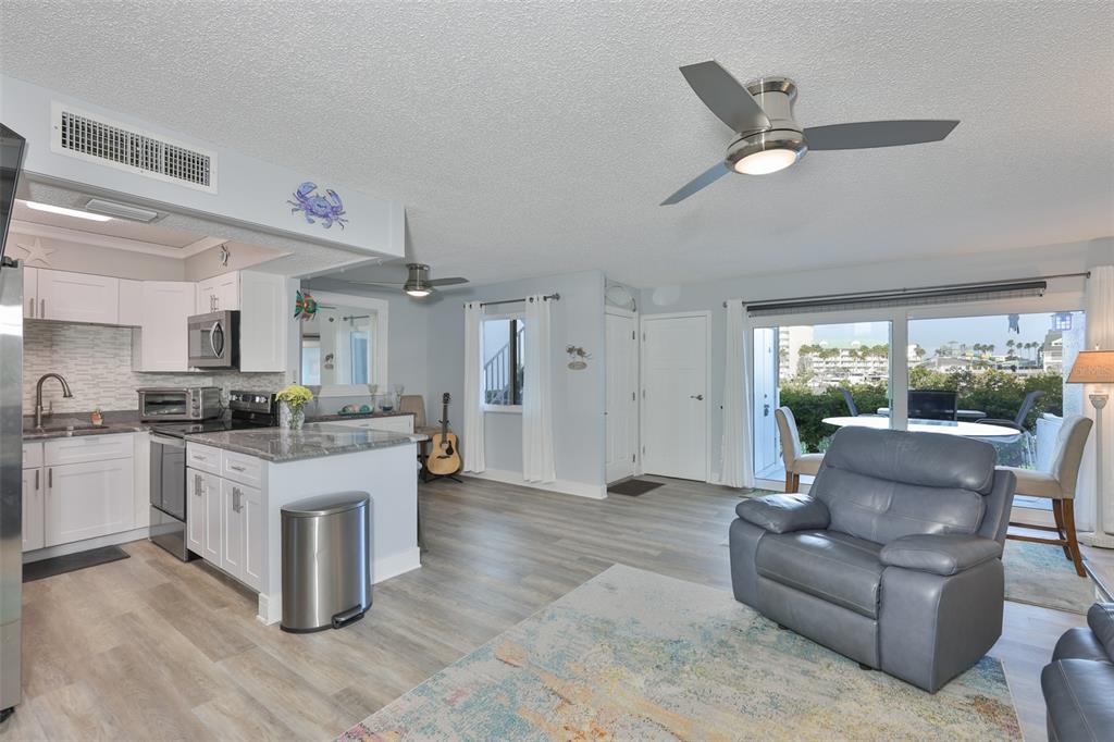 14800 Walsingham Road, Unit 1203 Largo, FL 33774 - Photo 11 of 68 a living room with stainless steel appliances kitchen island furniture and a large window