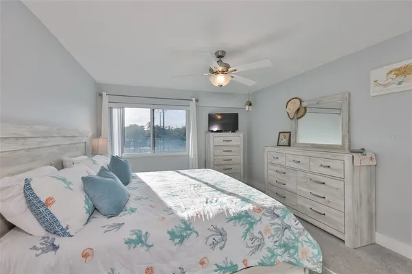 a bedroom with a bed and a flat tv screen on dresser