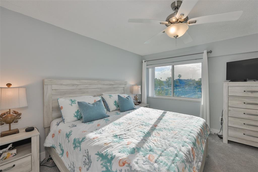 14800 Walsingham Road, Unit 1203 Largo, FL 33774 - Photo 15 of 68 a bedroom with a bed and a flat tv screen on dresser