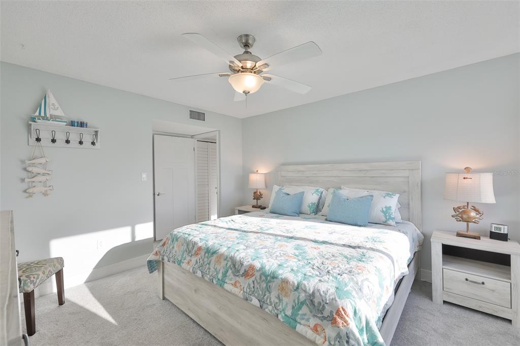 14800 Walsingham Road, Unit 1203 Largo, FL 33774 - Photo 16 of 68 a bedroom with a large bed and a chandelier