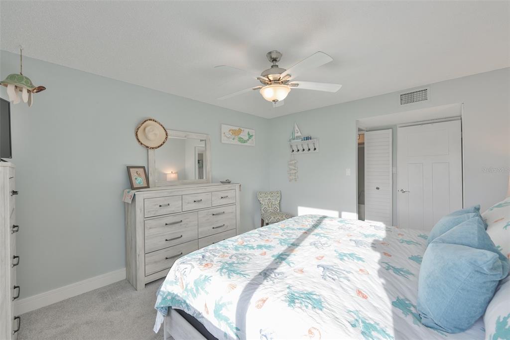 14800 Walsingham Road, Unit 1203 Largo, FL 33774 - Photo 17 of 68 a bedroom with a bed and a chandelier