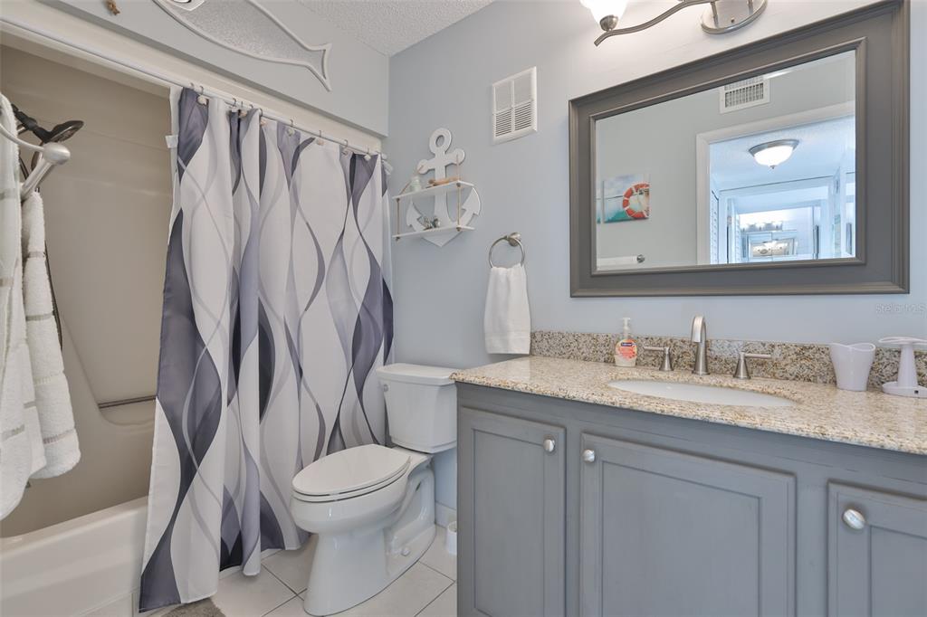 14800 Walsingham Road, Unit 1203 Largo, FL 33774 - Photo 19 of 68 a bathroom with a granite countertop sink toilet and shower