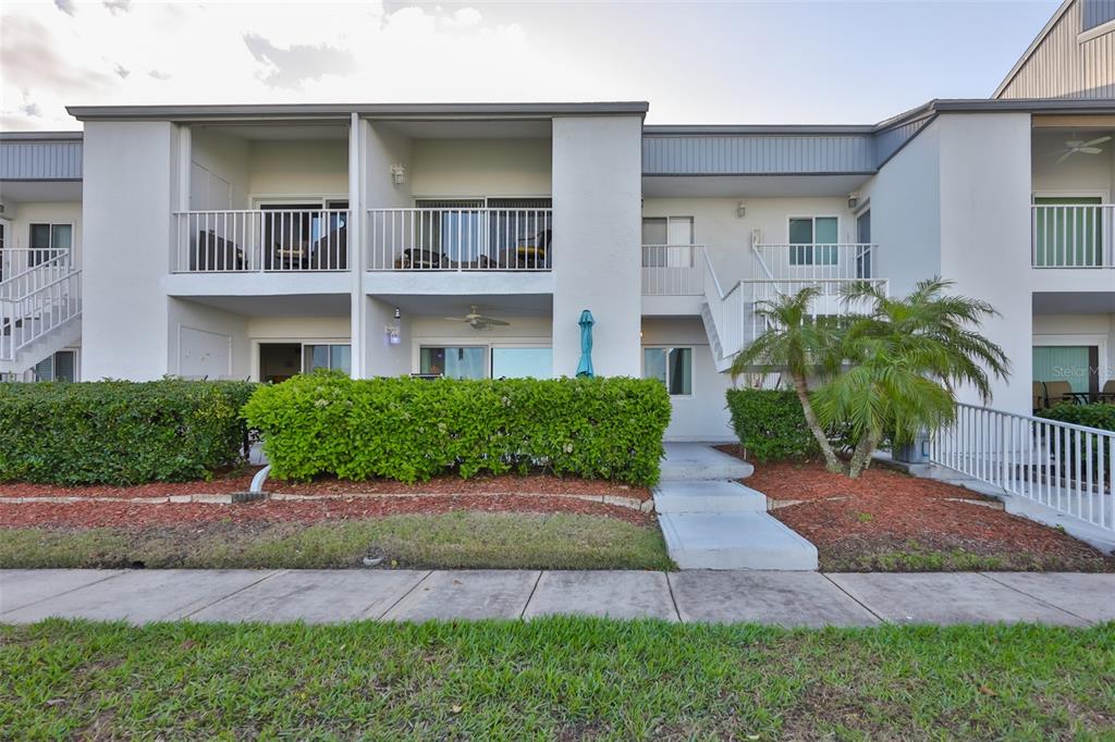 14800 Walsingham Road, Unit 1203 Largo, FL 33774 - Photo 2 of 68 a front view of house with yard and green space
