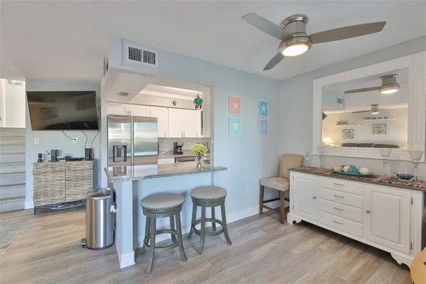 a kitchen with a table chairs refrigerator and cabinets