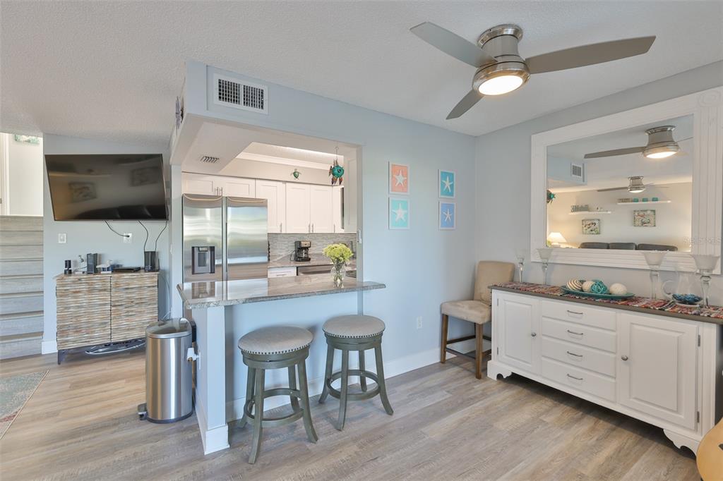 14800 Walsingham Road, Unit 1203 Largo, FL 33774 - Photo 3 of 68 a kitchen with a table chairs refrigerator and cabinets
