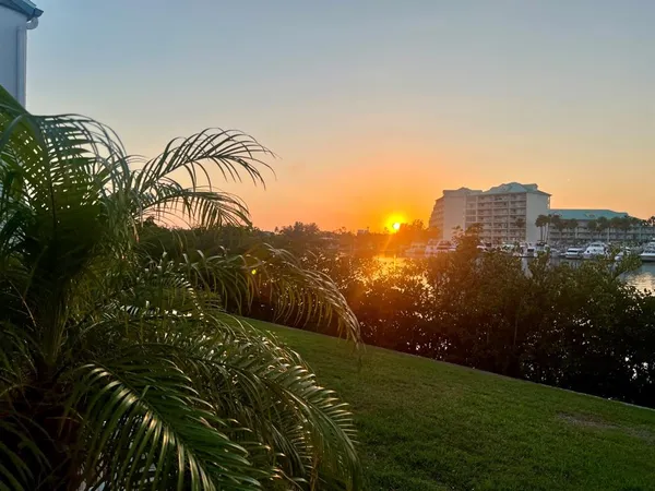 an aerial view of a city with lots of residential buildings ocean and mountain view in back