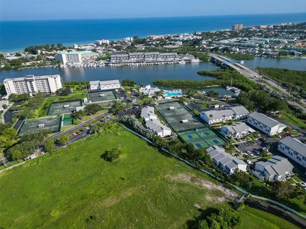 an aerial view of residential houses with outdoor space and lake view