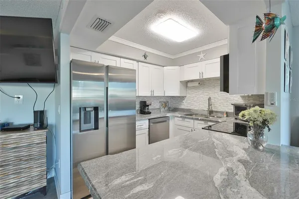 a kitchen with granite countertop a refrigerator and a stove