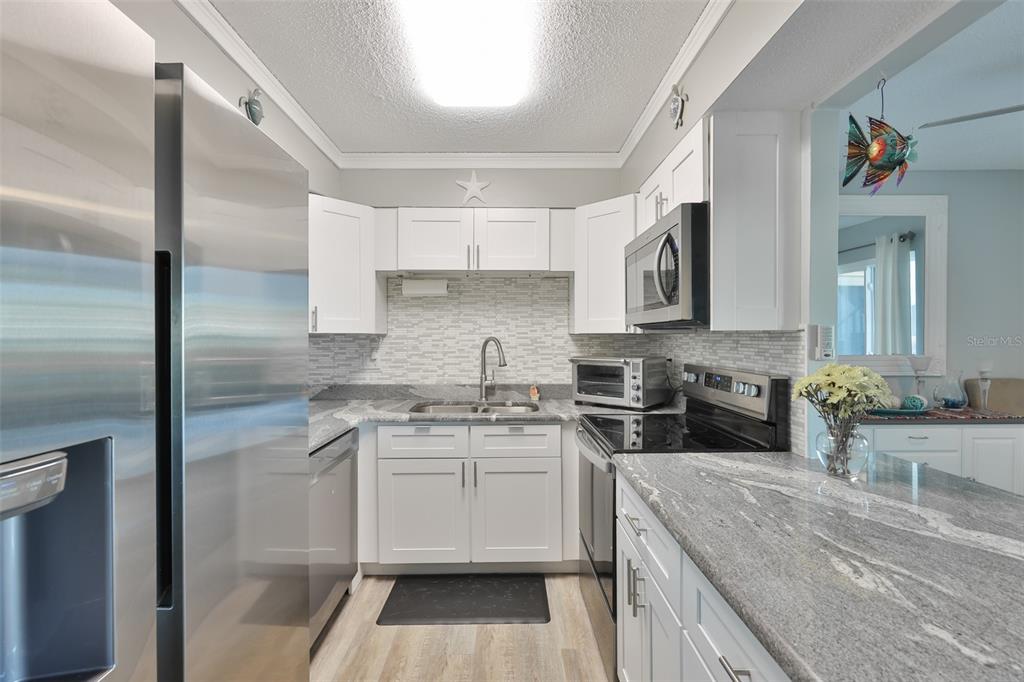 14800 Walsingham Road, Unit 1203 Largo, FL 33774 - Photo 7 of 68 a kitchen with a sink stove and cabinets
