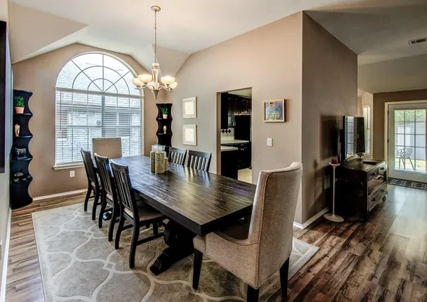 a view of a hallway with wooden floor and a bookshelf