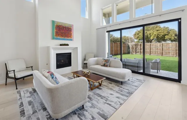 a living room with furniture large window and a fireplace