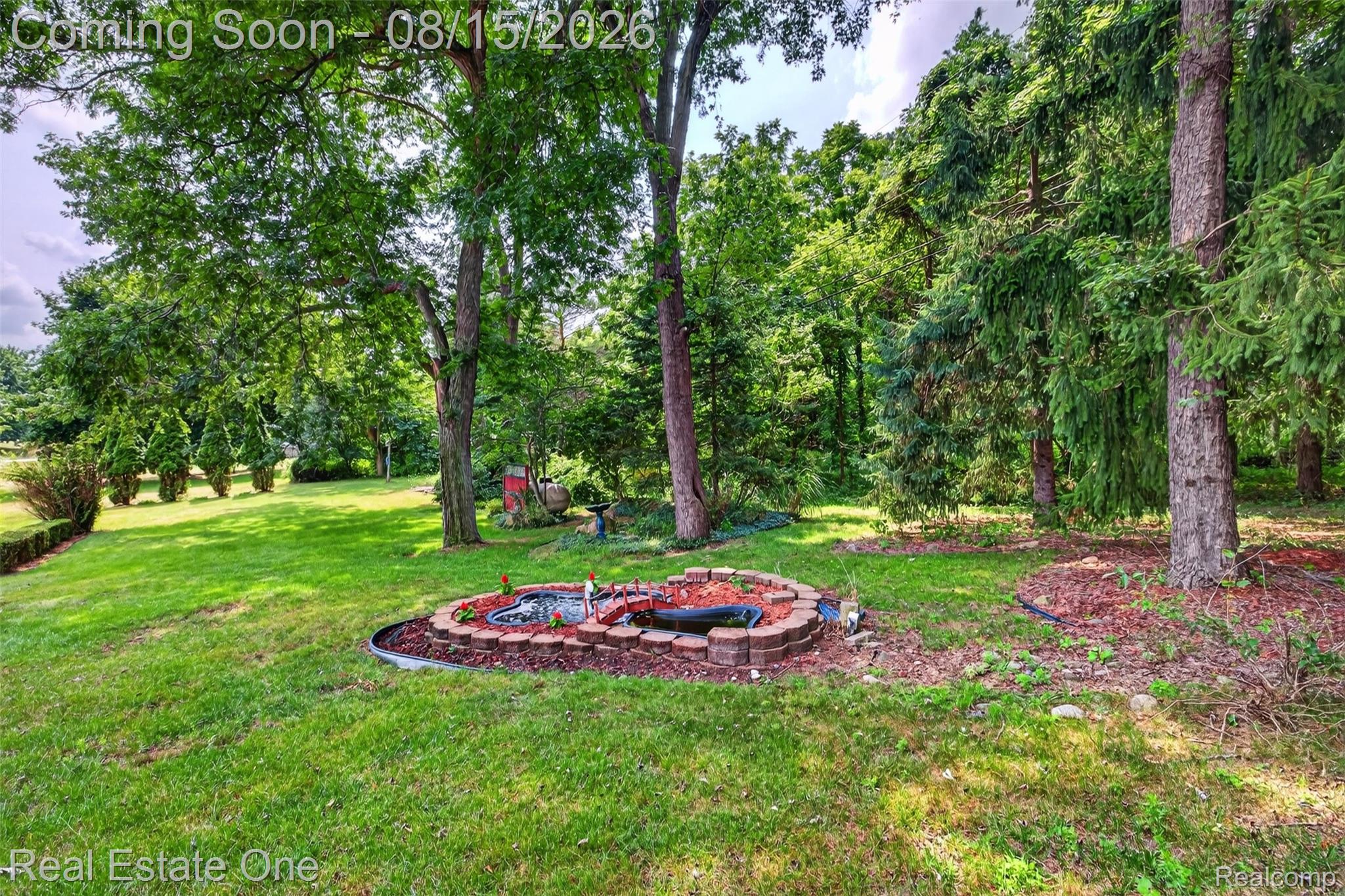 454 South Baldwin Road Oxford, MI 48371 - Photo 47 of 64 Expansive grassy yard featuring mature trees and a decorative brick-lined planting bed