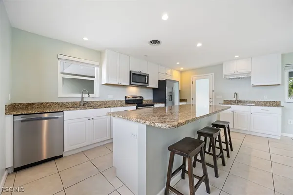 a kitchen with granite countertop a sink and cabinets