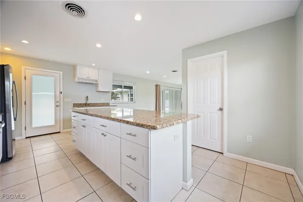 a large kitchen with granite countertop a stove and a sink