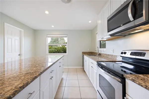 a kitchen with granite countertop a sink and cabinets