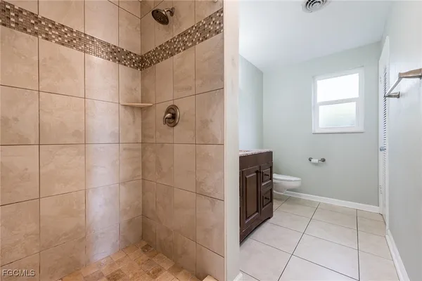 a bathroom with a granite countertop sink a toilet and a mirror