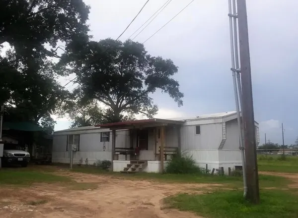 a view of a house with backyard and a tree