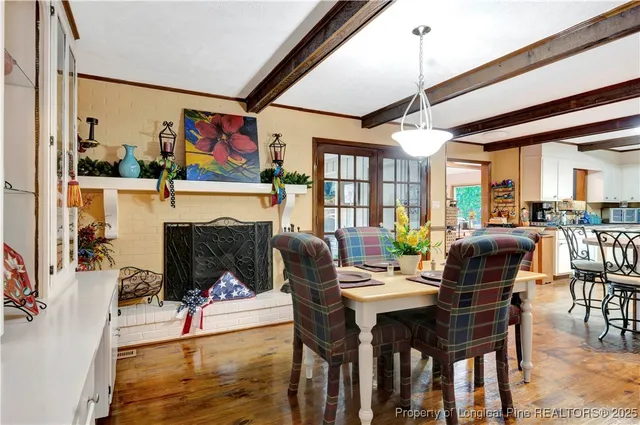 a dining room with furniture a floor to ceiling window and wooden floor