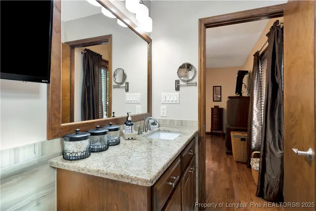 a bathroom with a granite countertop sink and a mirror